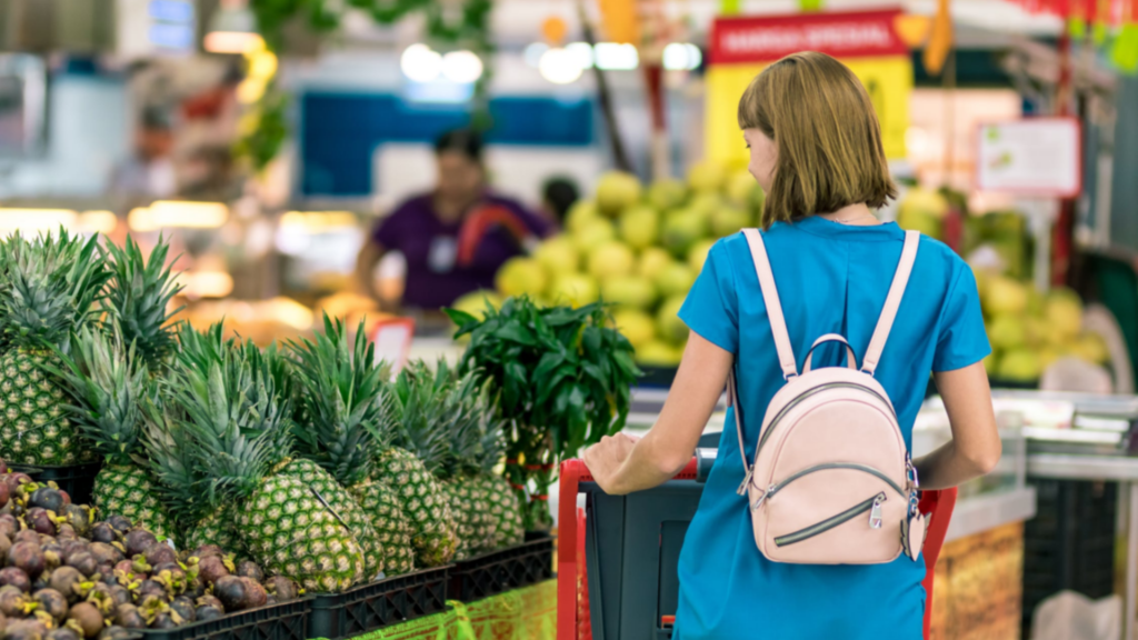 young lady shopping for pineapples in a supermarket